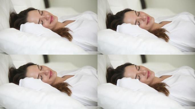 特写脸睡觉的迷人女人躺在白色床上