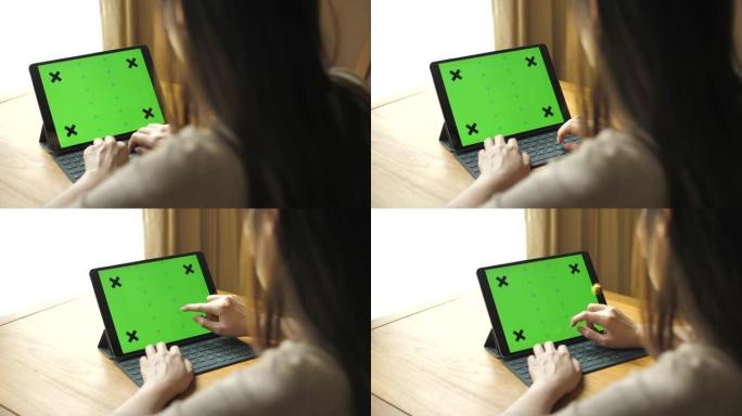 女人使用带键盘的绿屏平板电脑