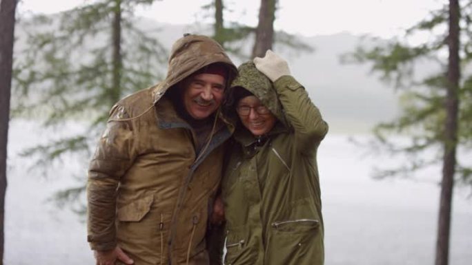 资深旅游夫妇在雨中微笑摆姿势