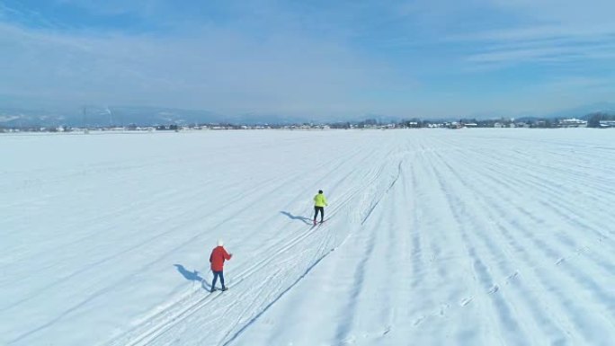 空中: 在阳光明媚的冬日，无法识别的活跃女性越野滑雪。