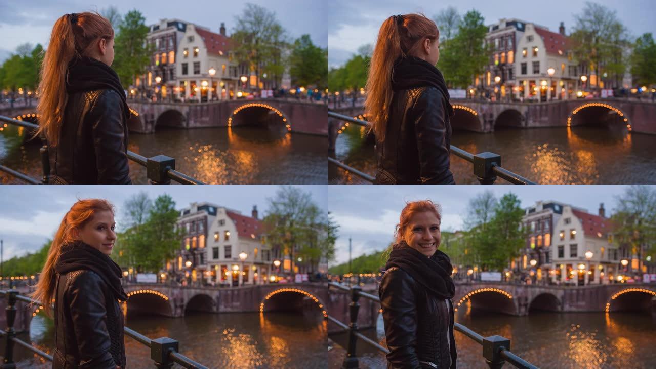 在阿姆斯特丹度假的女性游客，探索城市的夜生活，欣赏运河上的照明桥梁
