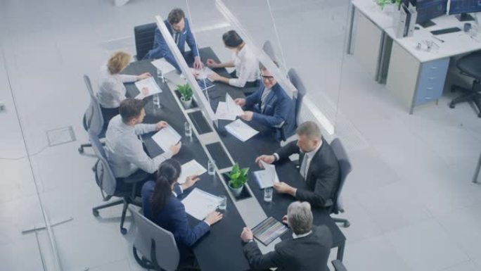 在公司办公室会议室中，由商人，投资者，高管和董事会成员组成的小组讨论，谈判和制定制胜策略。高角度相机