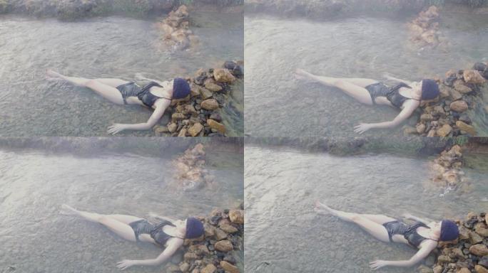穿着泳衣的女士浸泡在冰岛的温泉中