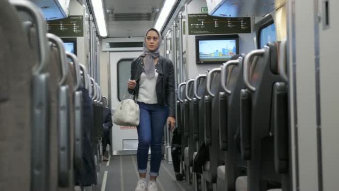 穆斯林妇女在通勤途中穿过火车