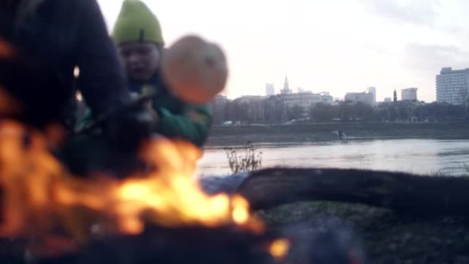 家庭烤香肠和篝火面包。冬季乐趣。城市中的河边