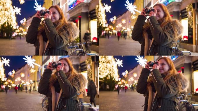 女人用老式相机拍摄圣诞节装饰城市