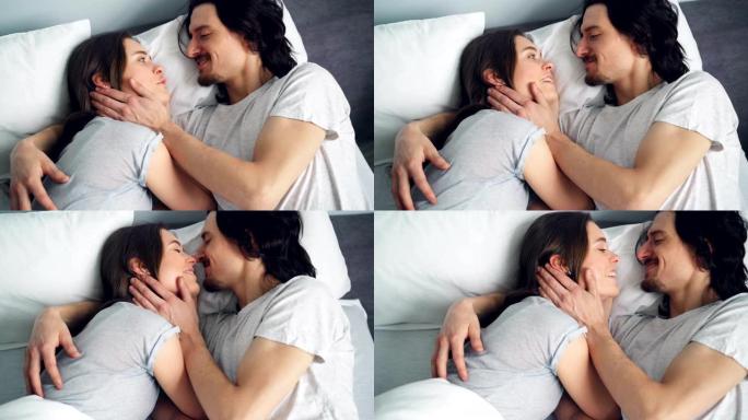 幸福夫妻在床上聊天拥抱接吻的高角度视图
