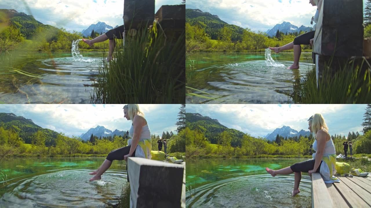 MS慢动作无忧无虑的年轻女子在阳光明媚的田园诗般的湖中泼水