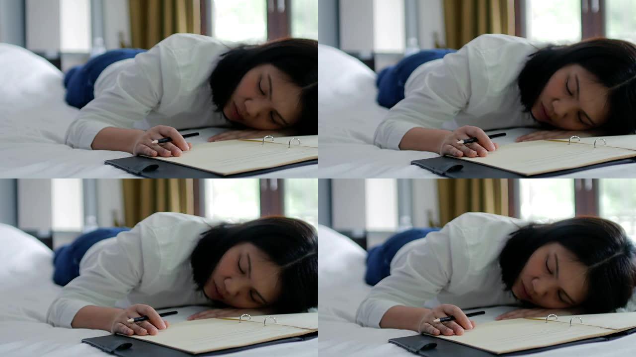 女人因辛苦工作而疲倦，与工作一起睡觉