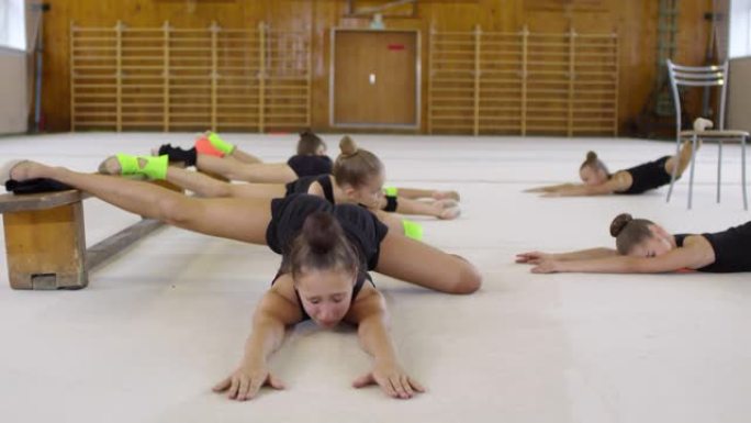 十几岁的女孩在体操课上伸展