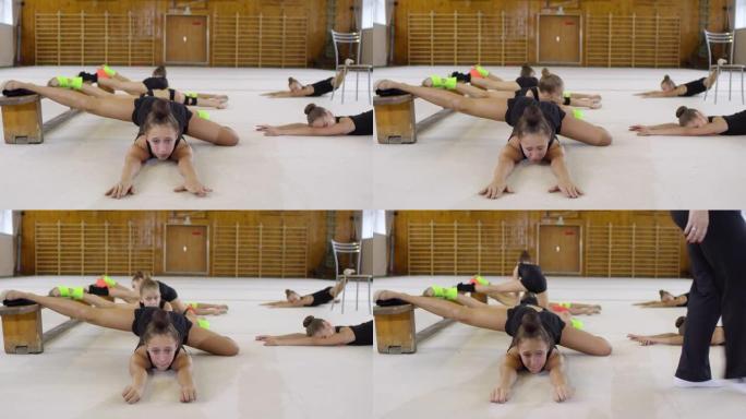 十几岁的女孩在体操课上伸展
