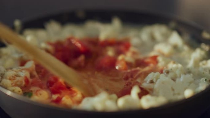 特写一个人在煎锅上准备健康素食的镜头。在现代厨房将番茄酱搅拌成素食主义者的菜肴。天然清洁饮食和健康的