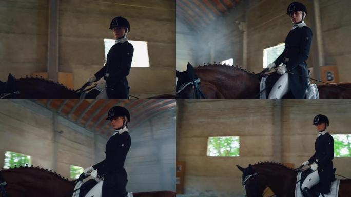 穿着专业服装的年轻女马术大师的电影慢动作特写正在骑马大厅练习赛马和盛装舞步比赛