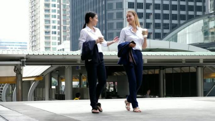 两名女商人在休息时间在市中心的市中心商务中心喝咖啡，慢动作