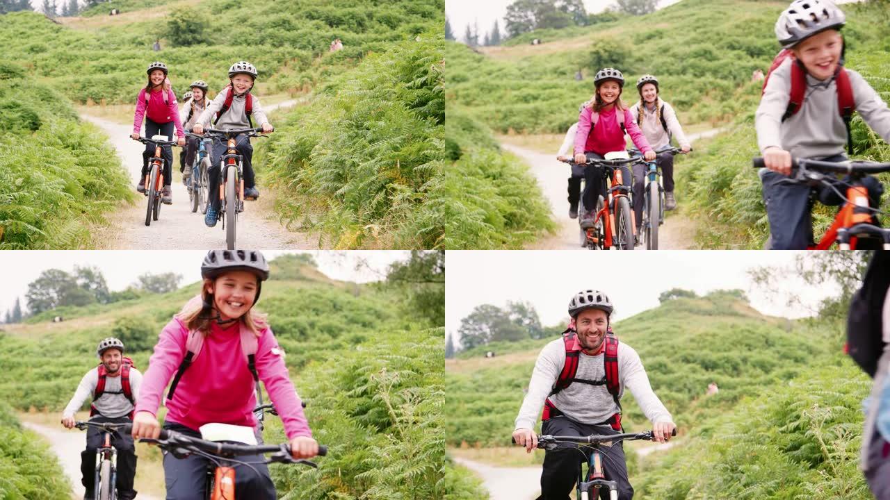 年轻的家庭在露营假期骑山地自行车玩得开心，特写，前视图，湖区，英国