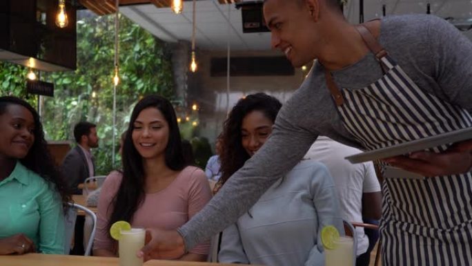 一群女性朋友在餐厅里用服务生刚带给他们的柠檬水敬酒