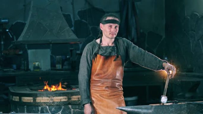 男铁匠站在铁砧附近，手持锤子。