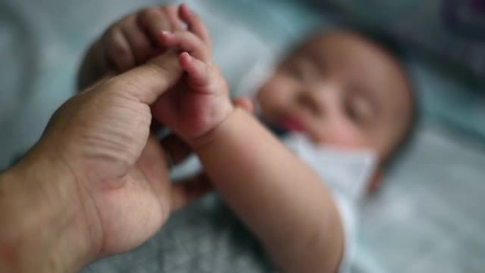 个人观点第一人称视角握着躺在床上看的男婴的手