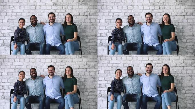 快乐的多元化商业团队看着相机坐在椅子上