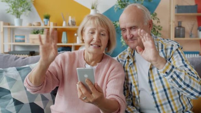 老年人进行在线视频通话，显示竖起大拇指的智能手机