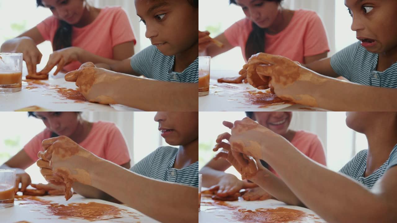 特写两个青春期前女孩的脏手在家里玩模型粘土，中间部分