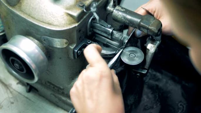 一位裁缝使用工厂缝纫机，特写。