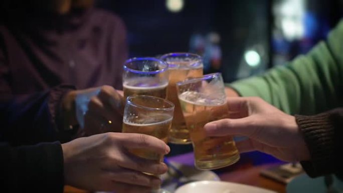 一群朋友在咖啡馆用啤酒庆祝和敬酒。慢动作