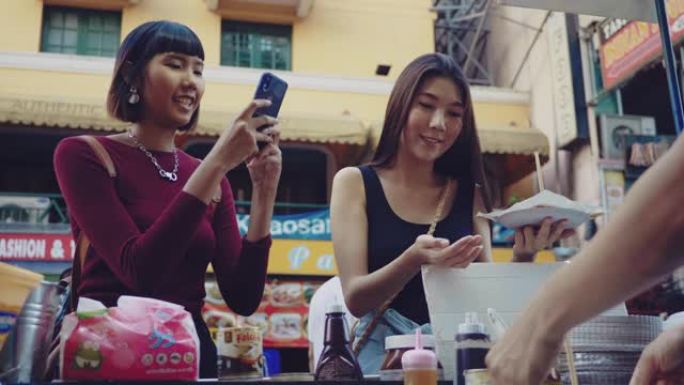 亚洲朋友游客在跳蚤市场购买roti。