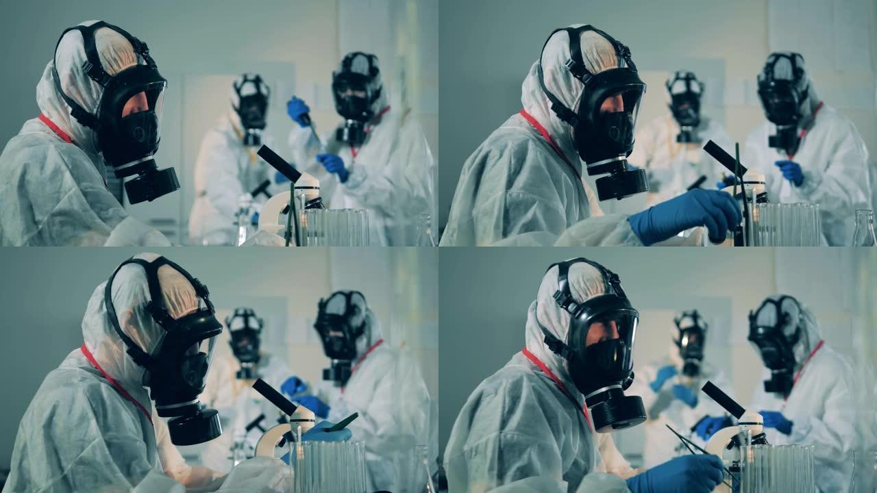 在COVID-19、冠状病毒抗体研究期间，身着防护服的实验室工作人员正在使用显微镜。