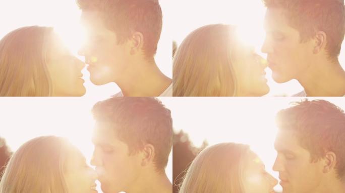 镜头耀斑: 英俊的男人轻轻地亲吻他开朗的女友的鼻子。