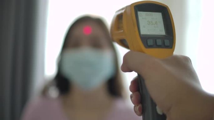 病人亚洲妇女面部和医生用体温计检查温度
