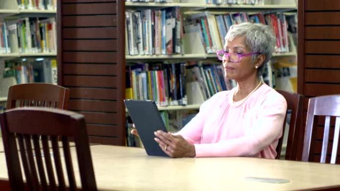 高级非裔美国妇女在图书馆读书