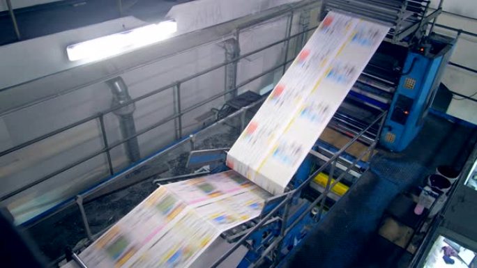 通过印刷机移动的新鲜印刷报纸