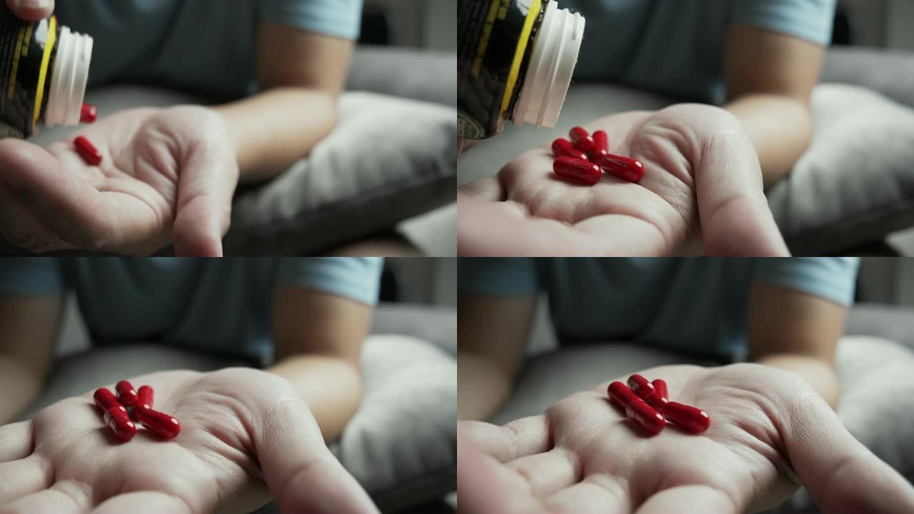 男人手上的红色药丸的4k镜头。医疗健康概念
