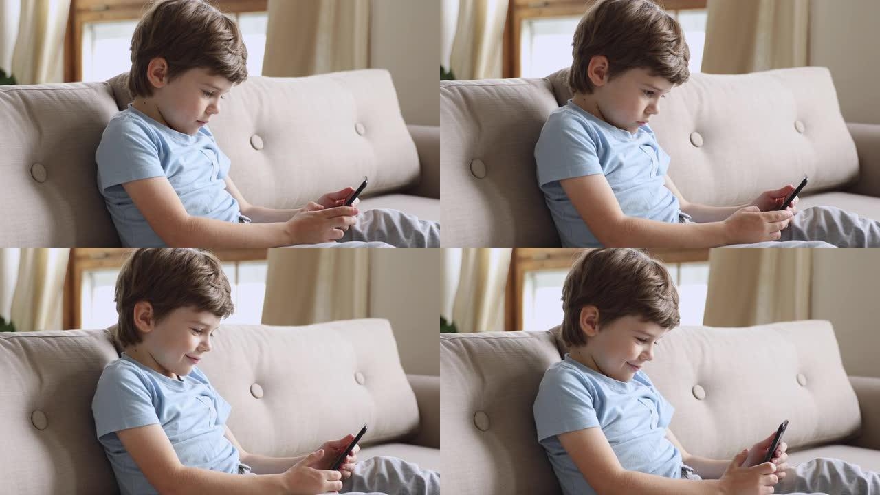 微笑的小孩在智能手机上玩网络游戏。