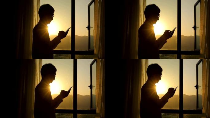 男子在日落时使用智能手机