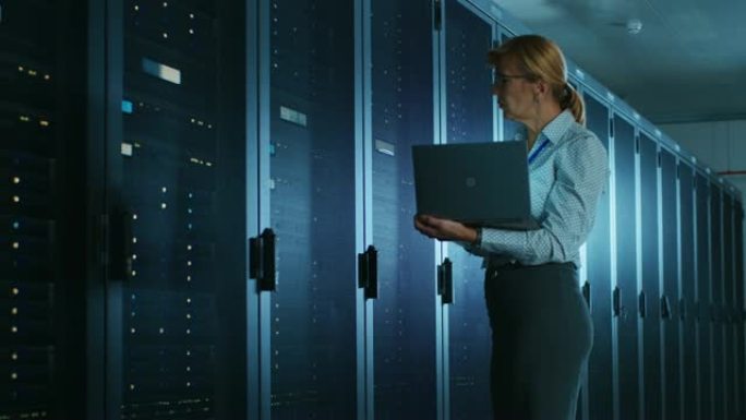 在数据中心: 女it技术人员打开机架式机柜并在笔记本电脑上运行维护程序，控制操作服务器的最佳功能。