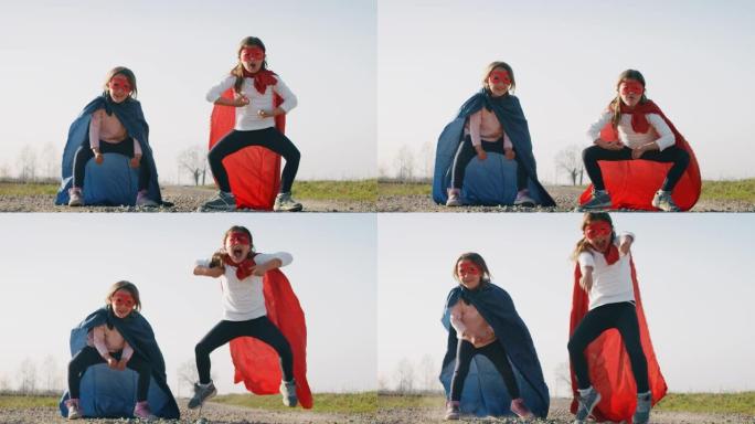 两个有趣的小女孩姐妹打扮成超级英雄的真实镜头，穿着红色和蓝色的舞蹈，玩得开心