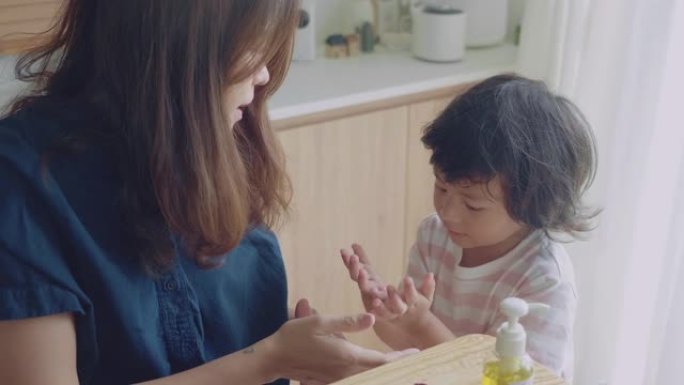 母亲用酒精洗手液清洁儿子的手保护孩子免受病毒侵害