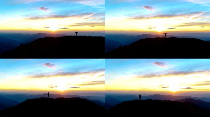 夕阳背景上站在山上的快乐男