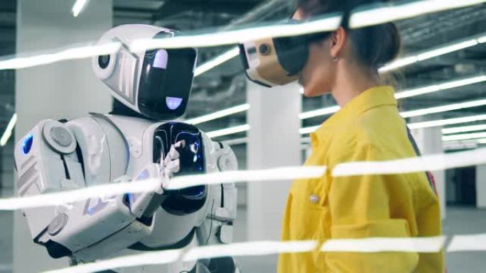 年轻女子戴着现代VR眼镜时触摸机器人的手。