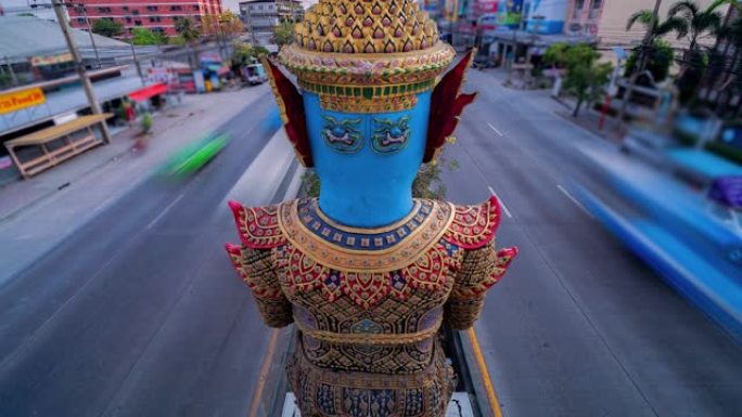 泰国的一条道路，道路中间矗立着一座巨大的雕像。泰国曼谷