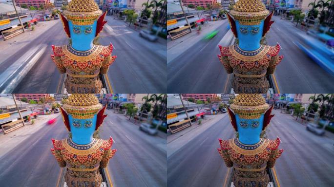 泰国的一条道路，道路中间矗立着一座巨大的雕像。泰国曼谷