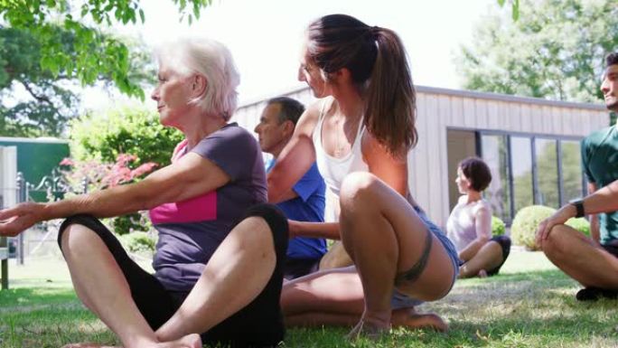 女教练在户外瑜伽课上帮助学生