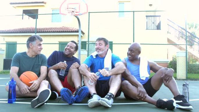 四个多民族男子休息，打篮球