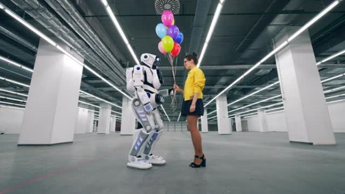 年轻女子正在向一个高大的机器人赠送气球