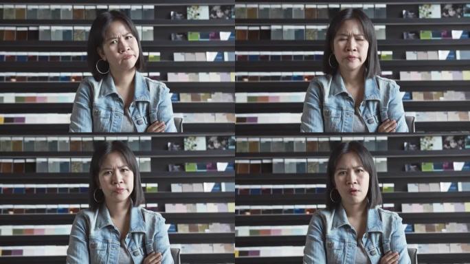 4K UHD慢动作: 愤怒的亚洲女性自由职业者感觉不好，看着相机。