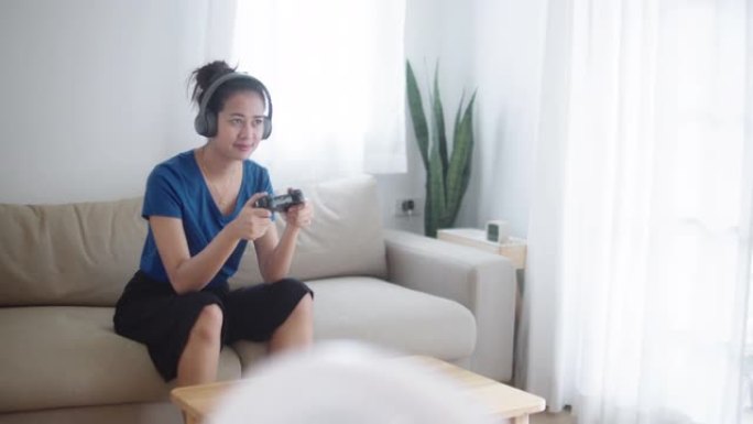 亚洲电子竞技玩家用她的耳机玩电子游戏。
