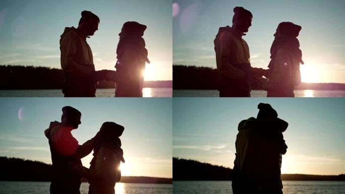 一对拥抱在湖码头上的夫妇。浪漫的日落