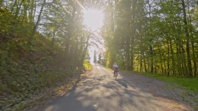 TS女人在乡村蜿蜒的道路上骑自行车穿过森林